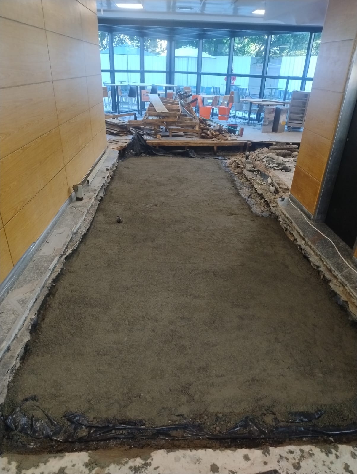 Obra em andamento com manta plástica e camada de areia